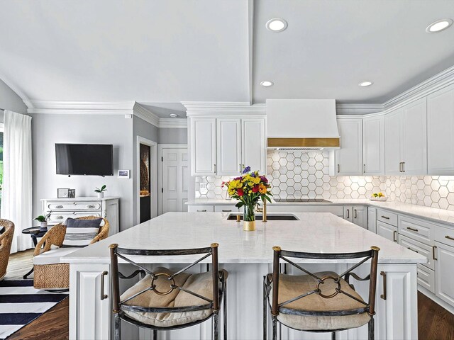 1004 Jones Pkwy, Brentwood, TN 37027 - kitchen featuring wall chimney exhaust hood, white cabinets, dark wood-type flooring, a kitchen island with sink, and recessed lighting