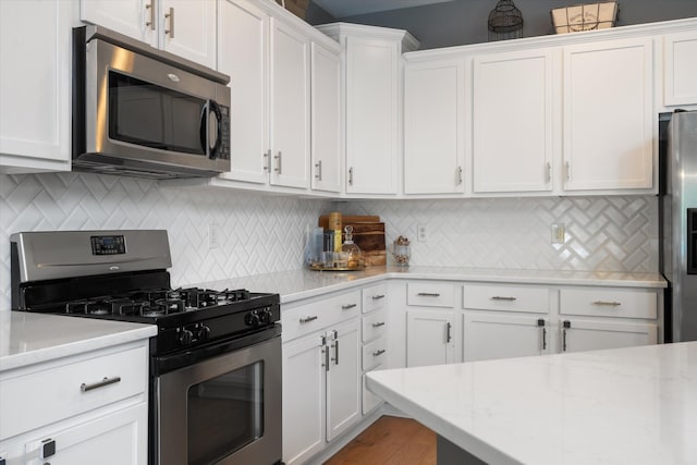 736 Arbor Springs Dr, Mount Juliet, TN 37122 - kitchen featuring appliances with stainless steel finishes, white cabinets, tasteful backsplash, and light stone counters