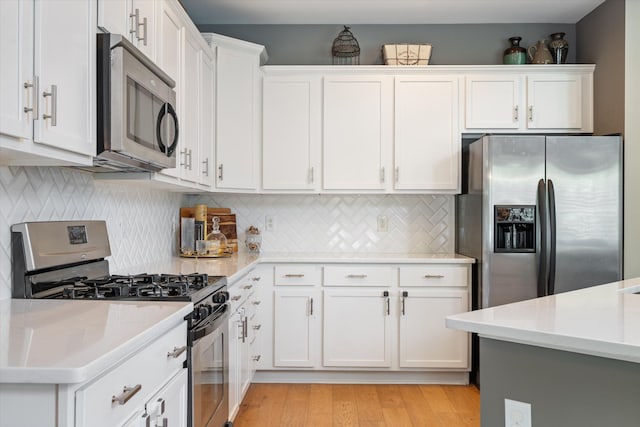 736 Arbor Springs Dr, Mount Juliet, TN 37122 - kitchen with stainless steel appliances, white cabinets, decorative backsplash, and light wood-style flooring