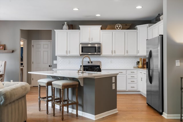 736 Arbor Springs Dr, Mount Juliet, TN 37122 - kitchen featuring appliances with stainless steel finishes, light countertops, light wood-style floors, white cabinets, and recessed lighting