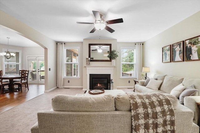 2740 Alvin Sperry Pass, Mount Juliet, TN 37122 - carpeted living room featuring a warm lit fireplace, arched walkways, a chandelier, ceiling fan, and baseboards