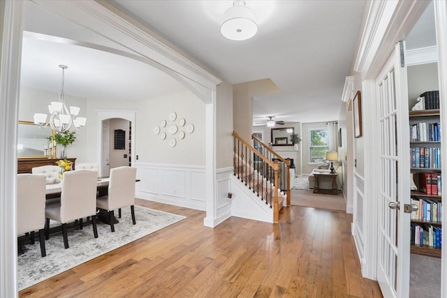 2740 Alvin Sperry Pass, Mount Juliet, TN 37122 - dining room featuring stairway, wood finished floors, a chandelier, arched walkways, and a wainscoted wall