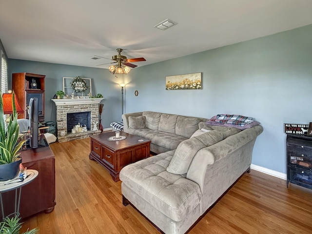 3113 Stafford Dr, Nashville, TN 37214 - living room with light wood-style flooring, a ceiling fan, a stone fireplace, and baseboards