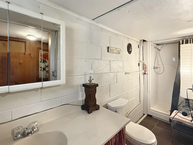 3113 Stafford Dr, Nashville, TN 37214 - bathroom with a shower stall, concrete block wall, toilet, and vanity