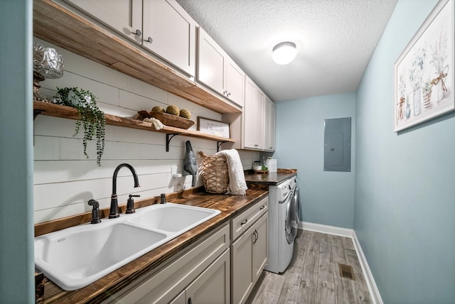 982 Red Bluff Way, Adams, TN 37010 - washroom with electric panel, light wood-style flooring, cabinet space, washer and clothes dryer, and baseboards