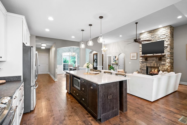 982 Red Bluff Way, Adams, TN 37010 - kitchen featuring arched walkways, appliances with stainless steel finishes, white cabinetry, ceiling fan, and dark wood-style flooring