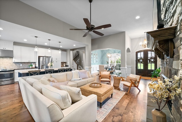 982 Red Bluff Way, Adams, TN 37010 - living area with arched walkways, recessed lighting, stairway, a towering ceiling, and wood finished floors