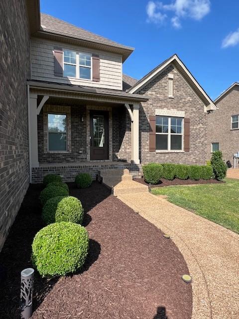 110 Sperance Ln, Gallatin, TN 37066 - view of front facade with brick siding, a porch, and a shingled roof