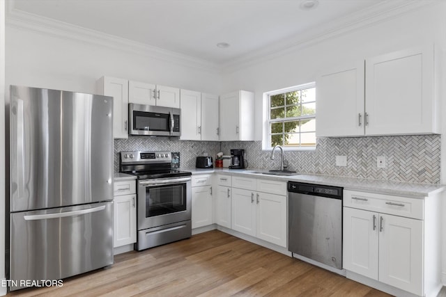 241 Hillside Ln, Lenoir City, TN 37771 - kitchen featuring stainless steel appliances, a sink, crown molding, white cabinets, and decorative backsplash