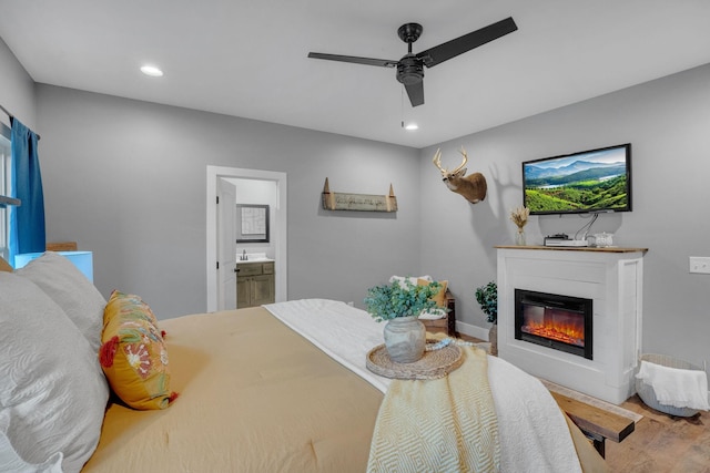 1270 Post Oak Rd, Belvidere, TN 37306 - bedroom featuring wood finished floors, a glass covered fireplace, recessed lighting, ensuite bathroom, and a ceiling fan