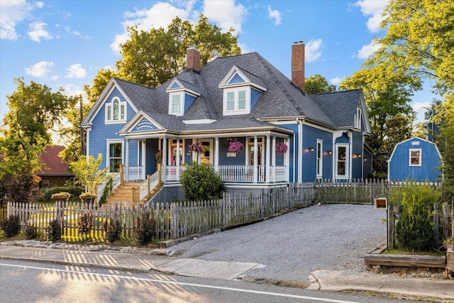 207 Main St E, Wartrace, TN 37183 - victorian home with a porch, a chimney, a fenced front yard, and driveway