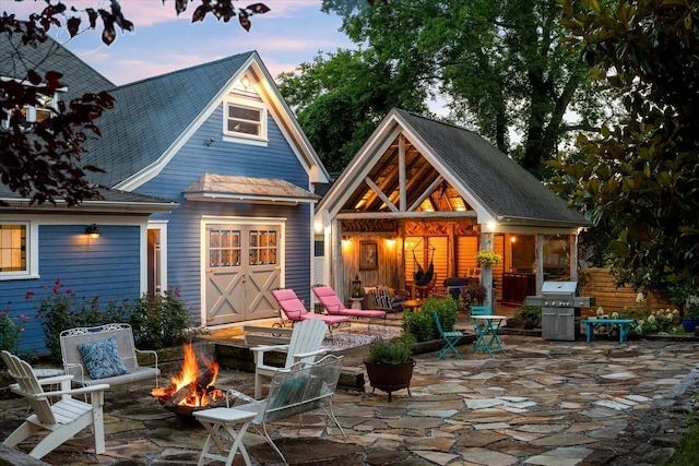 207 Main St E, Wartrace, TN 37183 - back of property at dusk featuring a fire pit and a patio