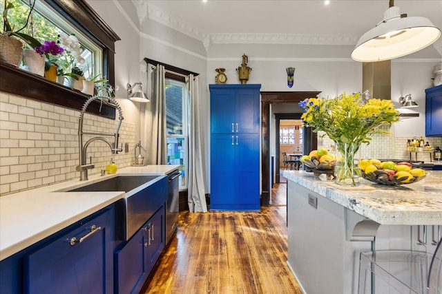 207 Main St E, Wartrace, TN 37183 - kitchen with blue cabinets, dark wood-style flooring, ornamental molding, light countertops, and backsplash