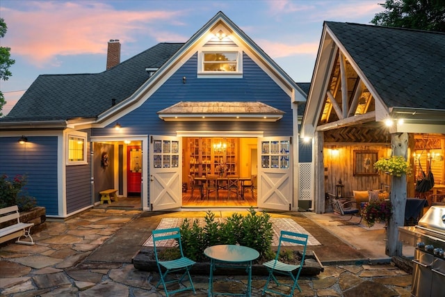 207 Main St E, Wartrace, TN 37183 - back of property at dusk featuring a patio and a chimney