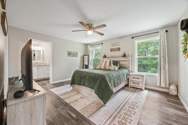 439 Ferry Bend Trl, Crossville, TN 38571 - bedroom featuring light wood-style flooring, baseboards, ensuite bath, and a ceiling fan