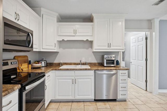123 Hubbard St, Hohenwald, TN 38462 - kitchen with appliances with stainless steel finishes, a sink, and white cabinets