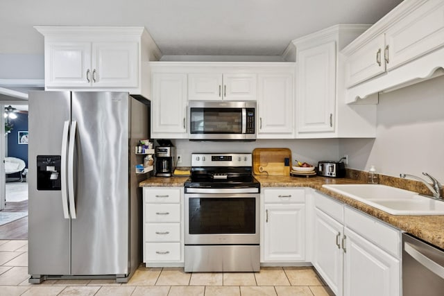 123 Hubbard St, Hohenwald, TN 38462 - kitchen featuring stainless steel appliances, a sink, light tile patterned floors, and white cabinetry