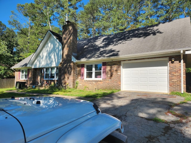 303 Shady Ln, Lawrenceburg, TN 38464 - view of front of home with driveway, brick siding, a chimney, a garage, and a jacuzzi