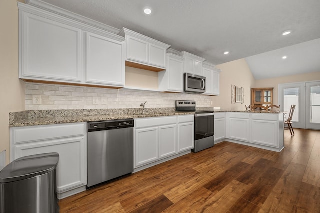4713 Pompano Ln, Murfreesboro, TN 37128 - kitchen featuring appliances with stainless steel finishes, dark wood-type flooring, lofted ceiling, white cabinets, and tasteful backsplash