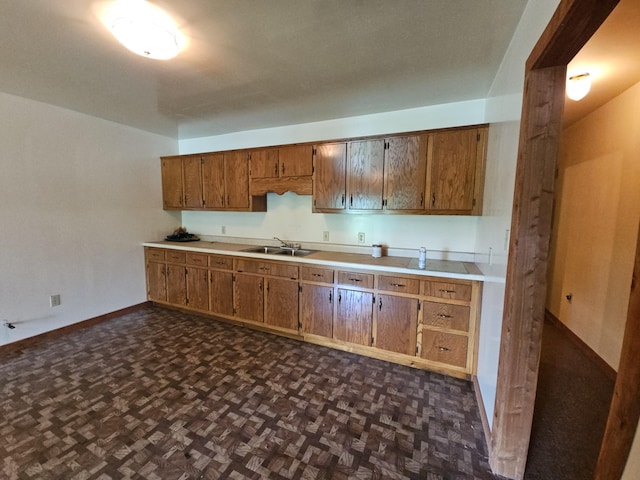 241 Peterson Loop, Holladay, TN 38341 - kitchen with a sink, baseboards, brown cabinets, and light countertops