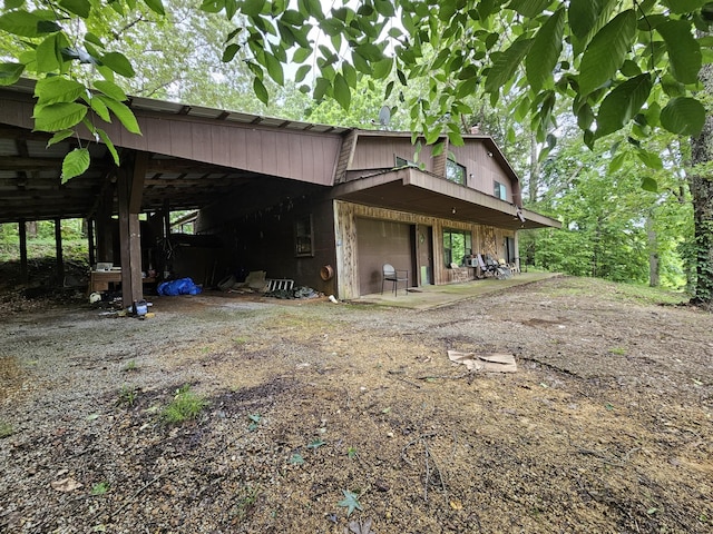 241 Peterson Loop, Holladay, TN 38341 - view of property exterior featuring a carport, dirt driveway, and a garage