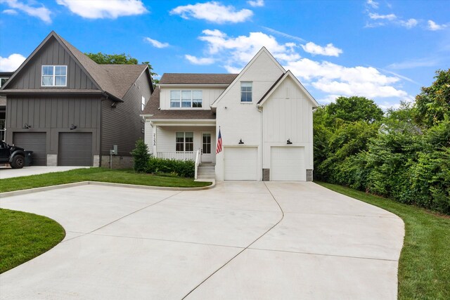 2123 Scott Ave Unit A, Nashville, TN 37216 - view of front of house featuring a garage, concrete driveway, board and batten siding, a front lawn, and roof with shingles