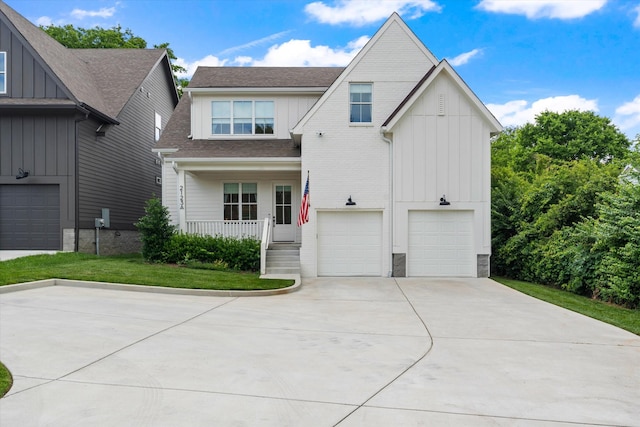 2123 Scott Ave Unit A, Nashville, TN 37216 - view of front facade featuring board and batten siding, a porch, driveway, an attached garage, and a shingled roof