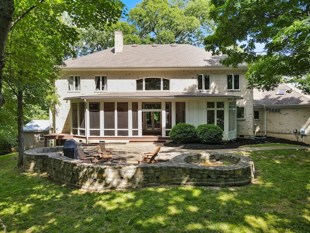 2754 Broyles Ln, Franklin, TN 37069 - rear view of house with a fire pit, a chimney, a yard, a patio area, and a sunroom