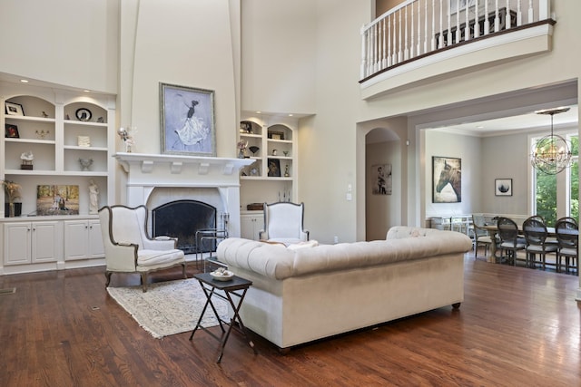 2754 Broyles Ln, Franklin, TN 37069 - living room featuring a towering ceiling, dark wood finished floors, built in shelves, a chandelier, and a fireplace