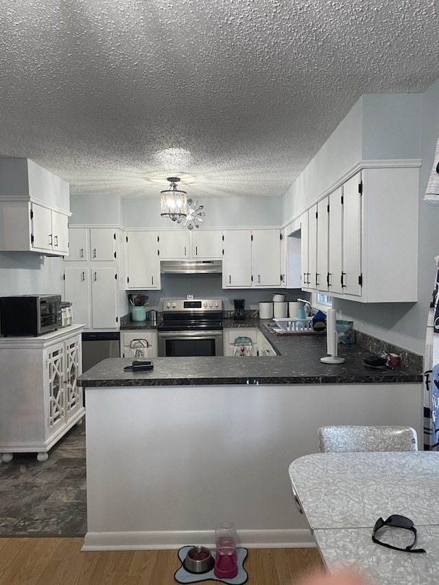 1700 Ellington Dr, Lafayette, TN 37083 - kitchen featuring stainless steel range with electric cooktop, under cabinet range hood, dark countertops, a textured ceiling, and white cabinetry