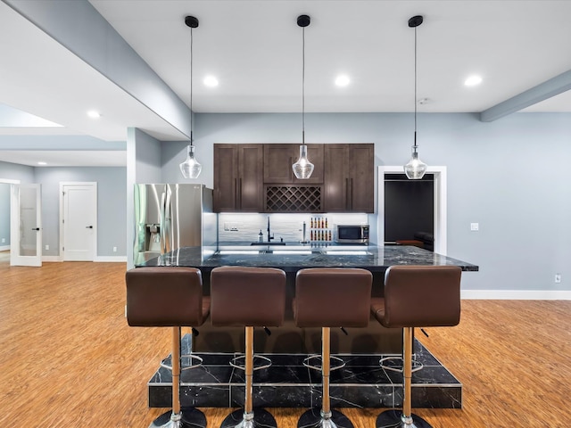 1288 Rogues Fork Rd, Bethpage, TN 37022 - kitchen featuring appliances with stainless steel finishes, dark brown cabinetry, a kitchen bar, decorative backsplash, and recessed lighting