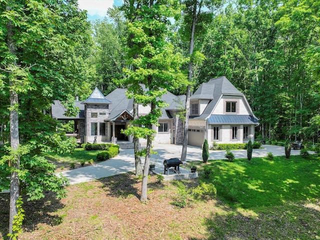 1288 Rogues Fork Rd, Bethpage, TN 37022 - view of front facade featuring a standing seam roof, concrete driveway, a metal roof, a front lawn, and stone siding