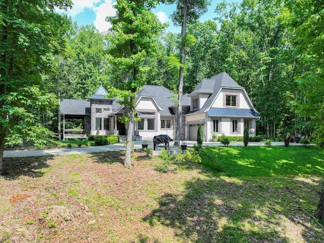 1288 Rogues Fork Rd, Bethpage, TN 37022 - view of front of home with a standing seam roof, stone siding, a front lawn, a metal roof, and a garage