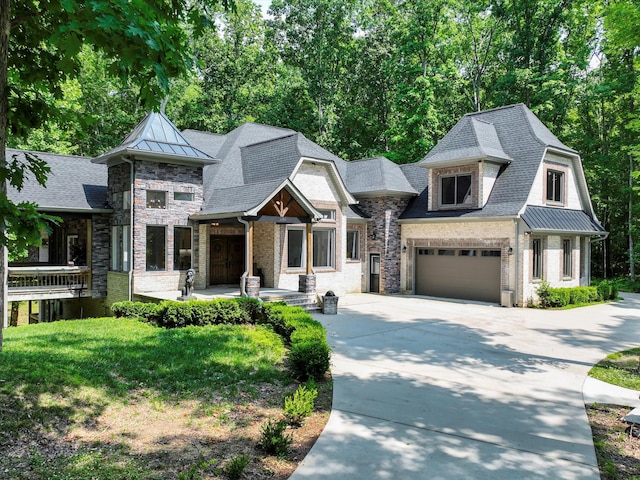 1288 Rogues Fork Rd, Bethpage, TN 37022 - view of front facade featuring concrete driveway, a standing seam roof, stone siding, a metal roof, and view of wooded area