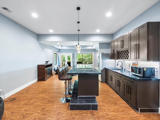 1288 Rogues Fork Rd, Bethpage, TN 37022 - kitchen with a breakfast bar, a kitchen island, stainless steel appliances, light wood finished floors, and recessed lighting