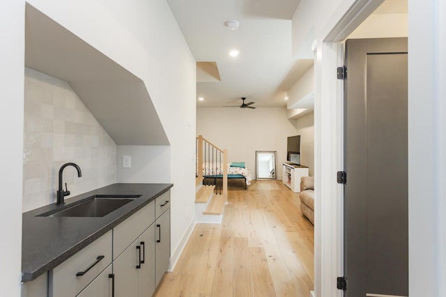 408D Moore Ave, Nashville, TN 37203 - bar featuring a sink, light wood-style floors, ceiling fan, decorative backsplash, and baseboards