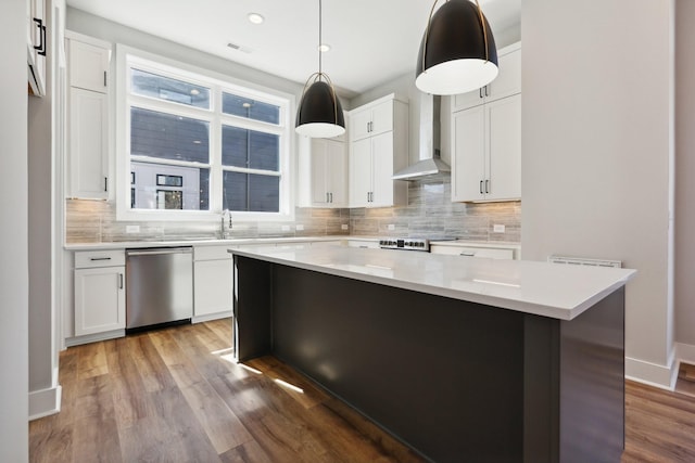 107 E 9th St Unit C5, Columbia, TN 38401 - kitchen with stainless steel dishwasher, backsplash, a kitchen island, light countertops, and wood finished floors