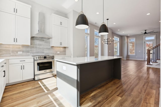 107 E 9th St Unit C5, Columbia, TN 38401 - kitchen featuring stainless steel range with electric cooktop, wall chimney range hood, light wood finished floors, backsplash, and recessed lighting