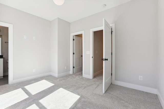 107 E 9th St Unit C5, Columbia, TN 38401 - unfurnished bedroom with light carpet, baseboards, and ensuite bath