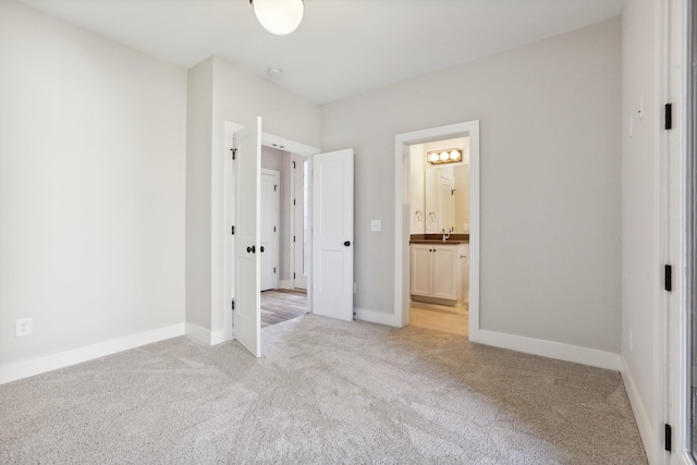 107 E 9th St Unit C5, Columbia, TN 38401 - unfurnished bedroom featuring light carpet, a sink, connected bathroom, and baseboards