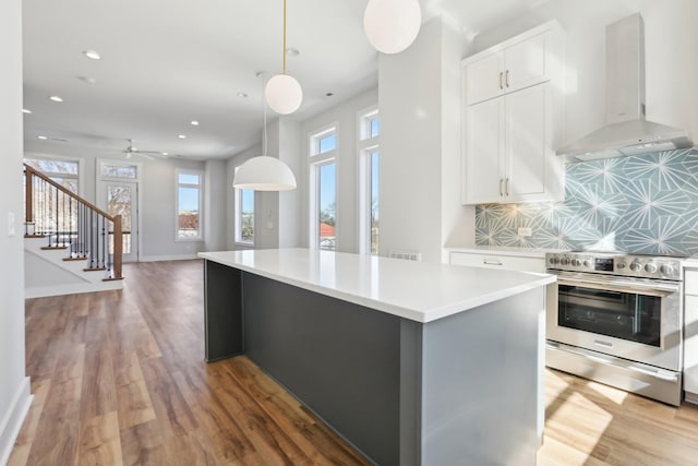 107 E 9th St Unit C6, Columbia, TN 38401 - kitchen with stainless steel electric range oven, wall chimney exhaust hood, light wood-style floors, backsplash, and a kitchen island