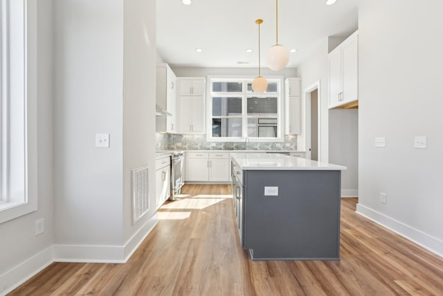 107 E 9th St Unit C6, Columbia, TN 38401 - kitchen featuring stainless steel electric range oven, white cabinetry, backsplash, a center island, and light wood-style floors