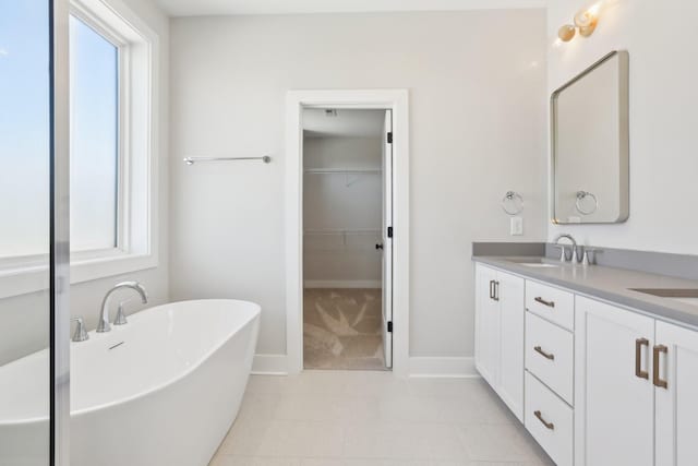 107 E 9th St Unit C6, Columbia, TN 38401 - bathroom featuring double vanity, a freestanding bath, a spacious closet, tile patterned floors, and baseboards