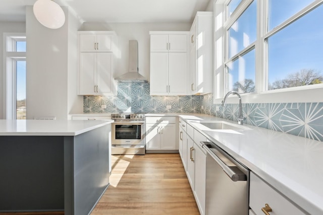 107 E 9th St Unit C6, Columbia, TN 38401 - kitchen featuring appliances with stainless steel finishes, wall chimney range hood, a sink, light countertops, and backsplash