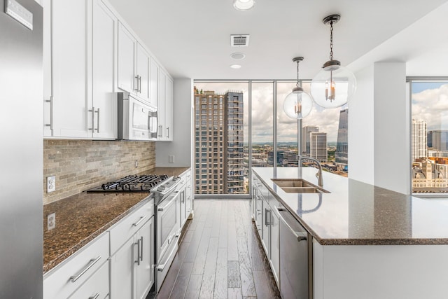 1212 Laurel St Unit 1902, Nashville, TN 37203 - kitchen with stainless steel appliances, a sink, decorative backsplash, dark wood-style floors, and expansive windows