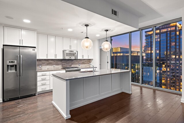 1212 Laurel St Unit 1902, Nashville, TN 37203 - kitchen with stainless steel appliances, a sink, floor to ceiling windows, dark wood-style flooring, and light stone counters