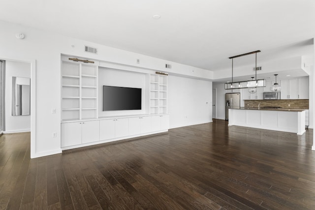 1212 Laurel St Unit 1902, Nashville, TN 37203 - unfurnished living room featuring baseboards, dark wood-style flooring, and built in shelves