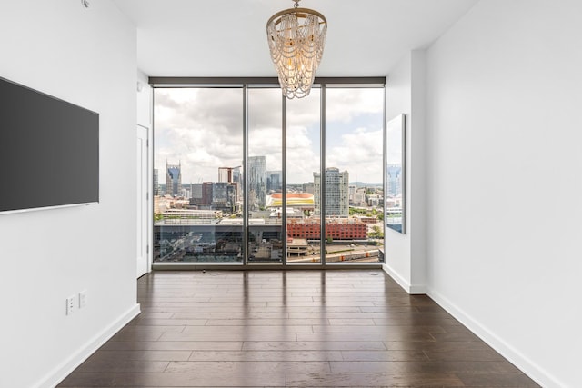 1212 Laurel St Unit 1902, Nashville, TN 37203 - spare room featuring a wall of windows, a chandelier, a view of city, and dark wood-type flooring