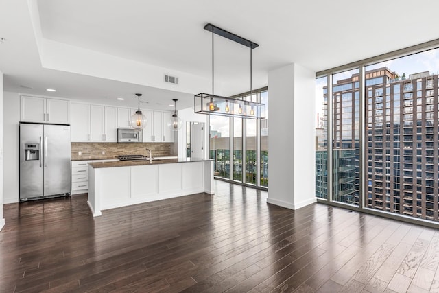 1212 Laurel St Unit 1902, Nashville, TN 37203 - kitchen with stainless steel fridge with ice dispenser, white microwave, floor to ceiling windows, dark countertops, and backsplash