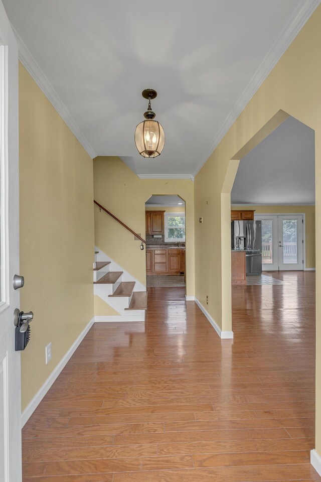 135 Carter Rd, Winchester, TN 37398 - foyer with arched walkways, light wood-style floors, baseboards, crown molding, and stairway